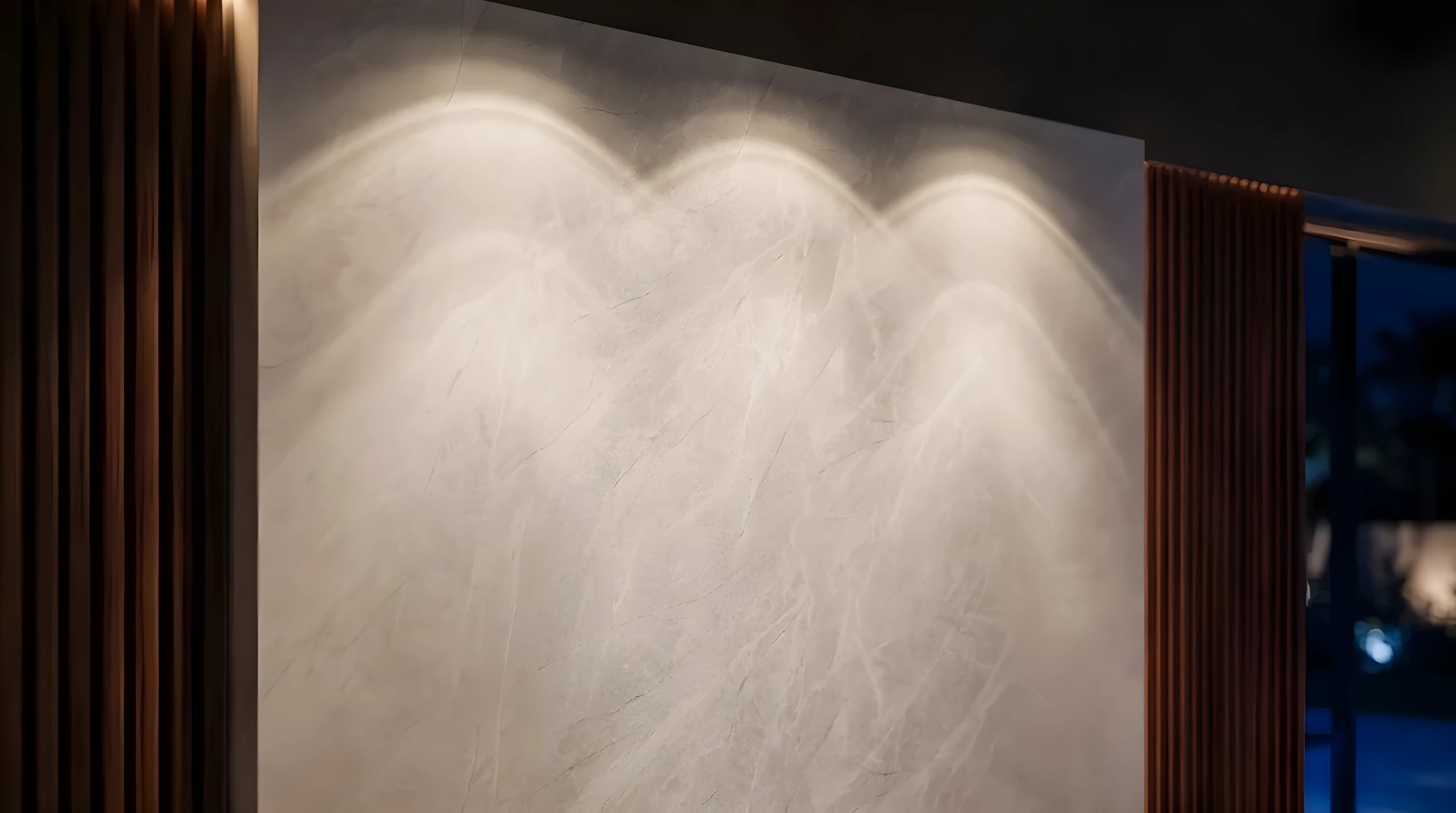 Luces cálidas rozando el panel con patrón de piedra